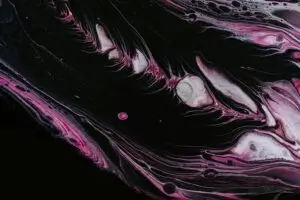 Textura abstrata em preto e rosa, com formas fluidas e onduladas.