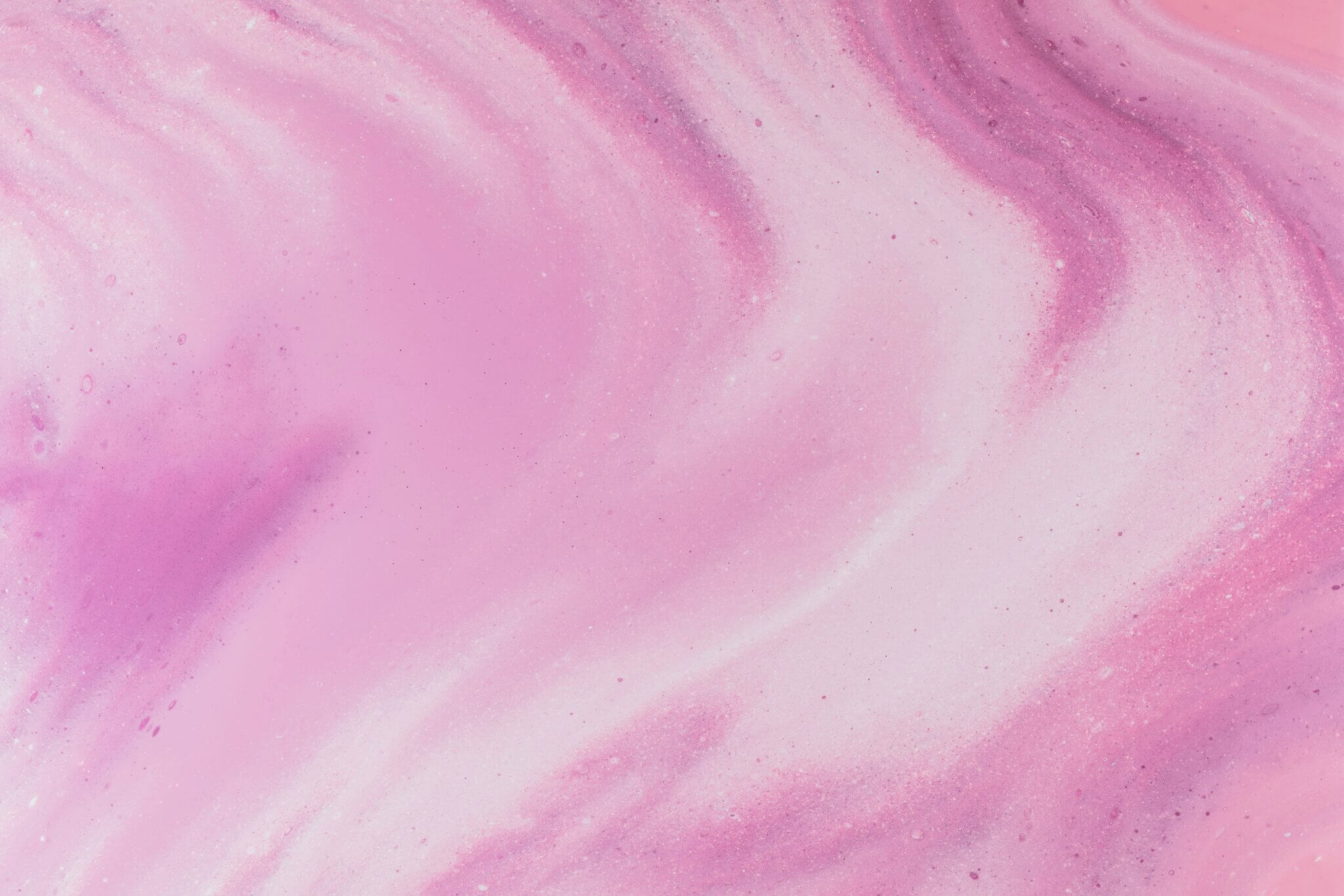 Pintura abstrata em estilo fluid art com redemoinhos orgânicos de tinta nas cores rosa chiclete, magenta e branco, criando um efeito de mármore líquido suave.