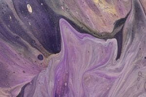 Textura abstrata em tons de roxo e dourado com padrões fluidos.